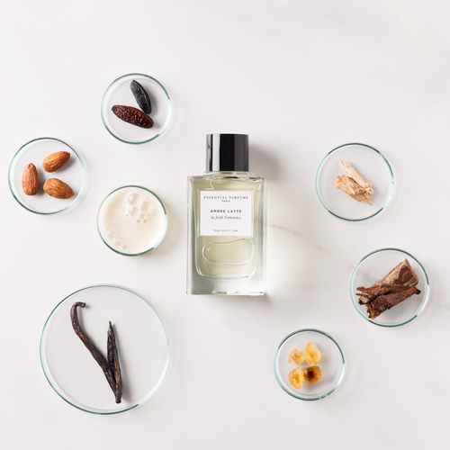 Essential Parfums Ambre Latte – flakon perfum otoczony mlecznymi i ambrowymi akordami podkreślającymi gourmandowy charakter kompozycji.