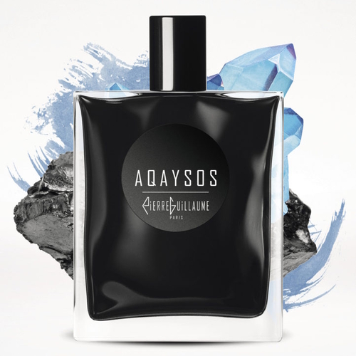 Flakon perfum Pierre Guillaume Aqaysos – elegancka, prostokątna butelka w kolorze czerni z połyskującym wykończeniem i minimalistycznym białym napisem „Aqaysos Pierre Guillaume Paris” na środku. W tle widoczne są fragmenty niebieskiego kryształu i ciemnego kamienia, symbolizujące kontrast między chłodem a głębią zapachu