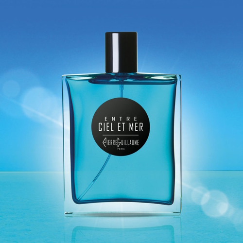 Flakon perfum Pierre Guillaume Entre Ciel et Mer w odcieniu błękitu, ustawiony na tle jasnego, niebieskiego nieba i powierzchni przypominającej wodę. Prosty, elegancki design butelki z czarnym korkiem i okrągłą etykietą podkreśla świeży, morski charakter zapachu