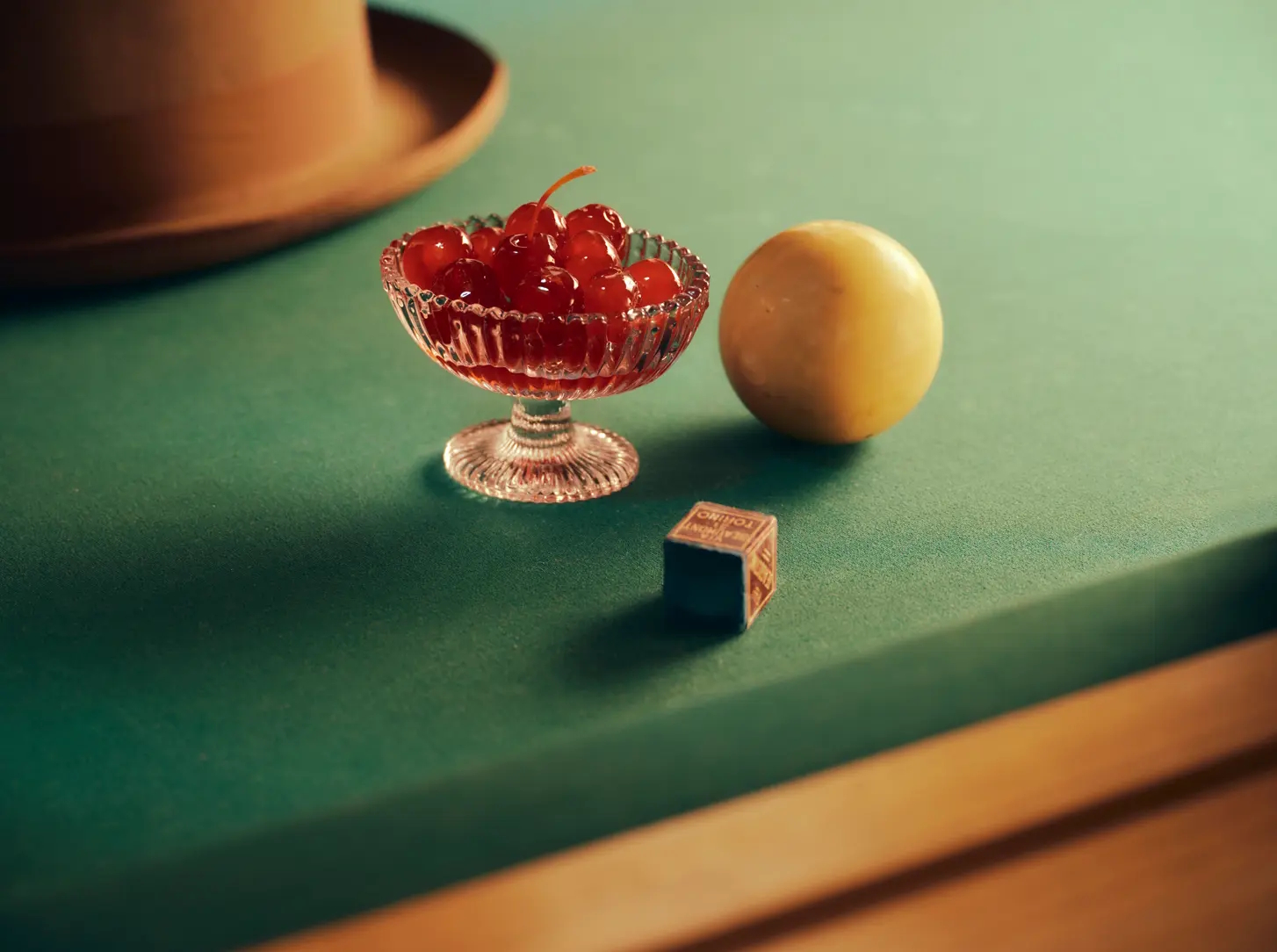 Detal inspirowany wieczornym rytuałem – filiżanka kawy i wiśniowy napój w ciepłym świetle.